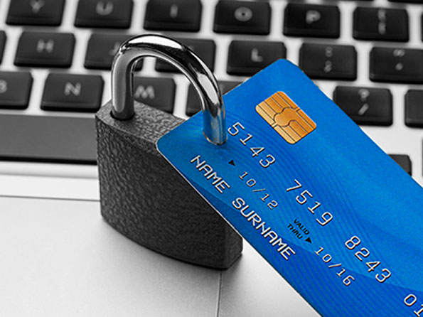key lock on a laptop 	keyboard with a credit card attached