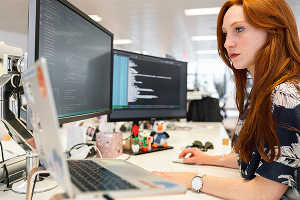 Web developer working on complex code looking intently at the computer code