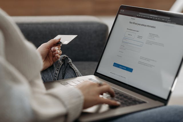 laptop with person holding credit card